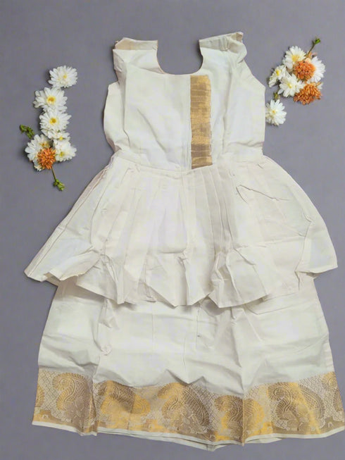 White traditional outfit with gold embroidery on a maroon fabric background
